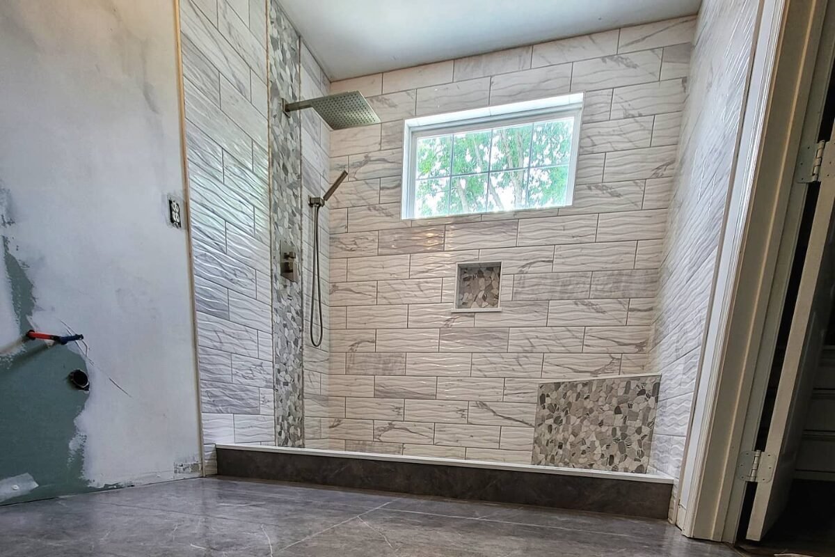 Ongoing tub-to-shower conversion in Rock Hill, SC, showcasing intricate white and gray textured tiles.