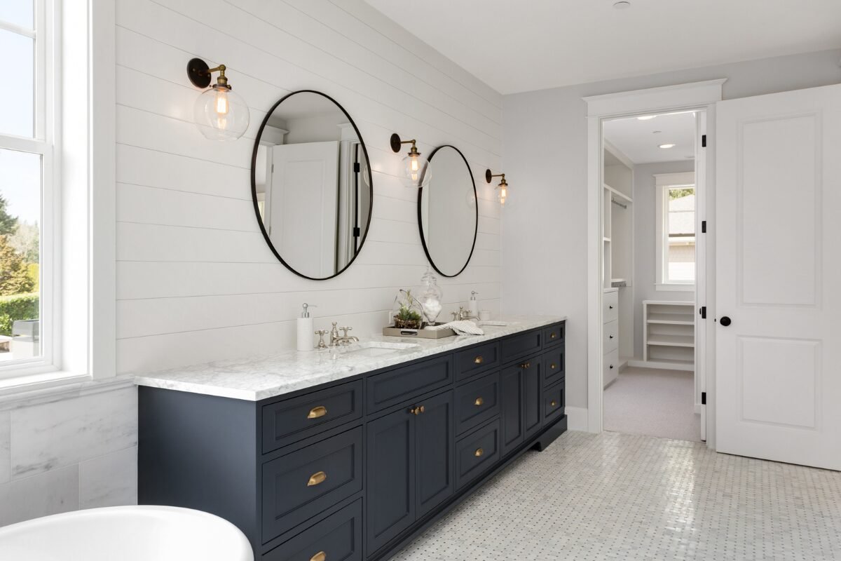Bathroom renovation in Rock Hill, SC, featuring elegant shiplap walls, tile flooring, and a striking navy blue vanity.